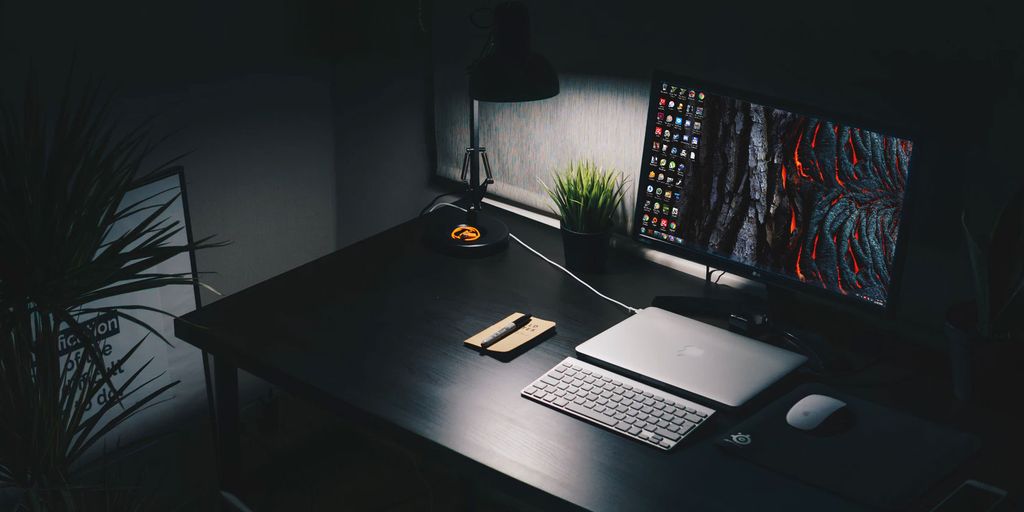 digital privacy concept with hooded person using computer in dark room