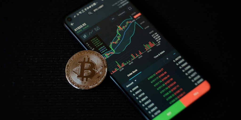 a bitcoin sitting on top of a smart phone